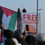 Crowd at İstanbul protest holding Palestinian flags advocating for freedom.