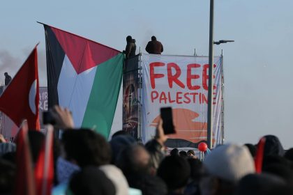 Crowd at İstanbul protest holding Palestinian flags advocating for freedom.